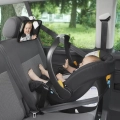 Dziecko w foteliku samochodowym montowanym tyłem do kierunku jazdy, widoczne w lusterku samochodowym Chicco przymocowanym do zagłówka, umożliwiającym obserwację malucha podczas jazdy.