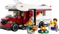 Zestaw LEGO City Wakacyjny Kamper 60454 z otwartym pojazdem, grającą na gitarze minifigurką i rodziną przy ognisku.