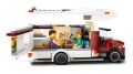Otwarty kamper LEGO City 60454 z minifigurkami rodziny siedzącej przy stole i kompletnym wyposażeniem wnętrza.