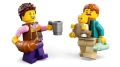 Minifigurki rodziny z zestawu LEGO City Kamper 60454 trzymające rogalika, kubek i butelkę dla dziecka.