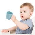 Dziecko uczące się pić z czerwonego kubka treningowego BabyOno FLOW — praktyczny kubek wspierający samodzielność.